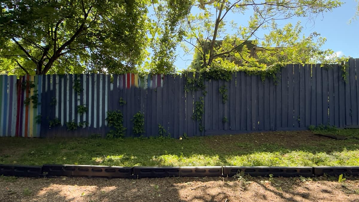 A continuation of the perimeter fence at Hasbrouck Street Park with an unfinished paint pattern.