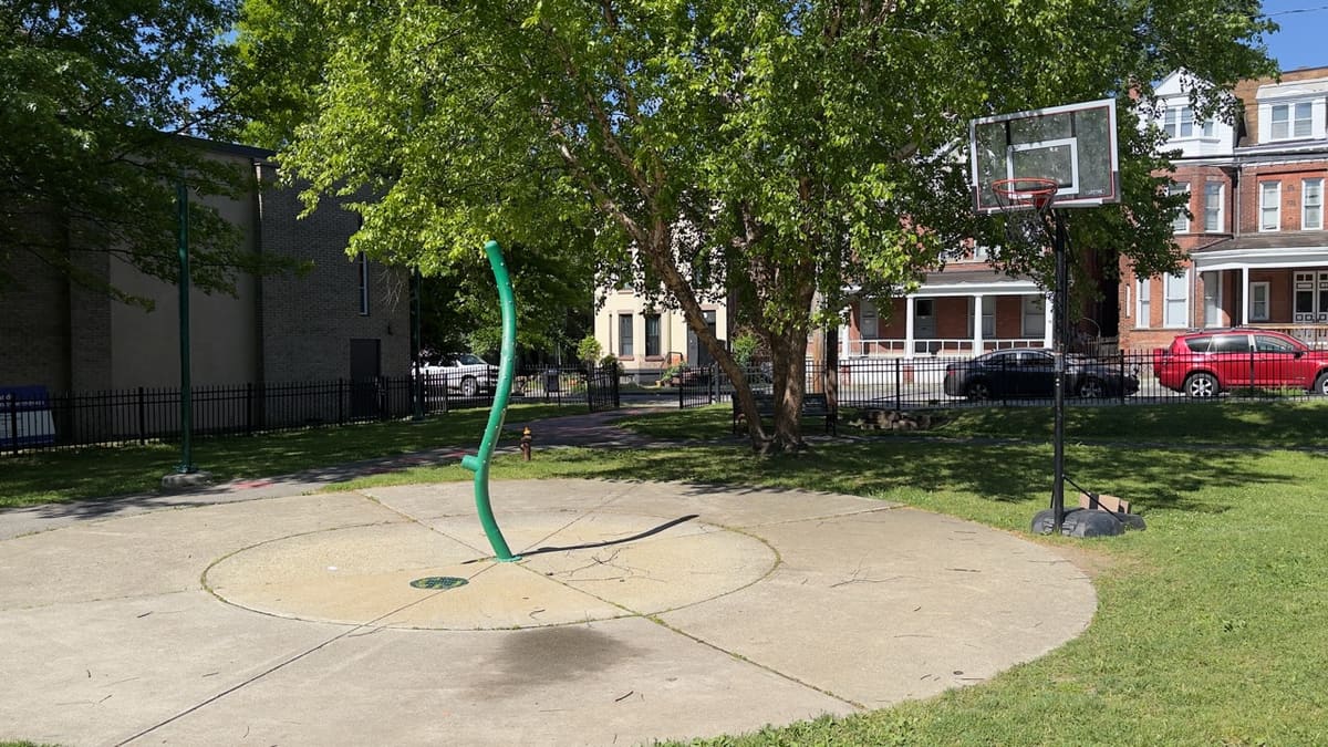 The splash pad area at Audrey Carey Park with a makeshift basketball hoop set up by kids.